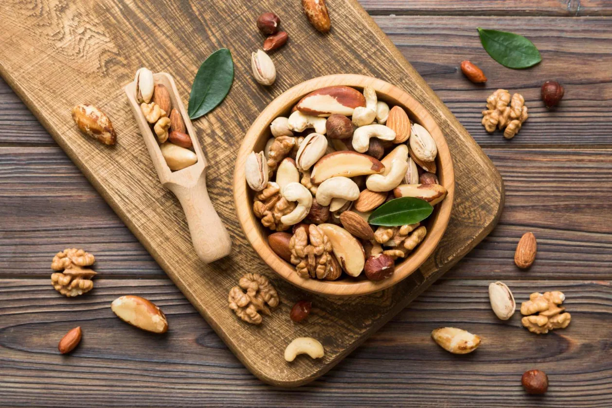 mixed nuts on wooden platter as part of healthy diet